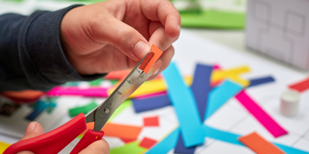 close-up of hand cutting paper