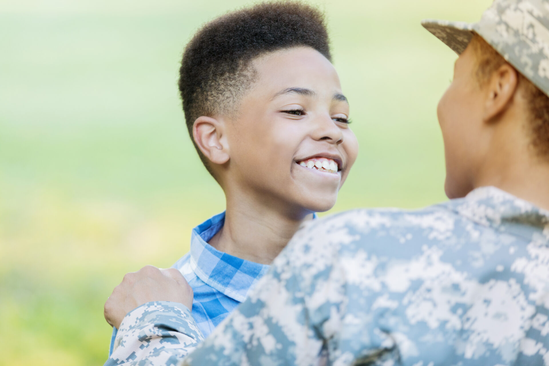Preteen boy smiles while reuniting with his military mom.