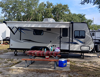 JAYCO Travel Trailer Jay Feather X23B Side View with Awning Extended and picnic table in front