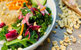 Thai Peanut Chicken bowl with quinoa, carrots, kale, diced chicken, Thai peanut sauce, cucumbers and chopped peanuts